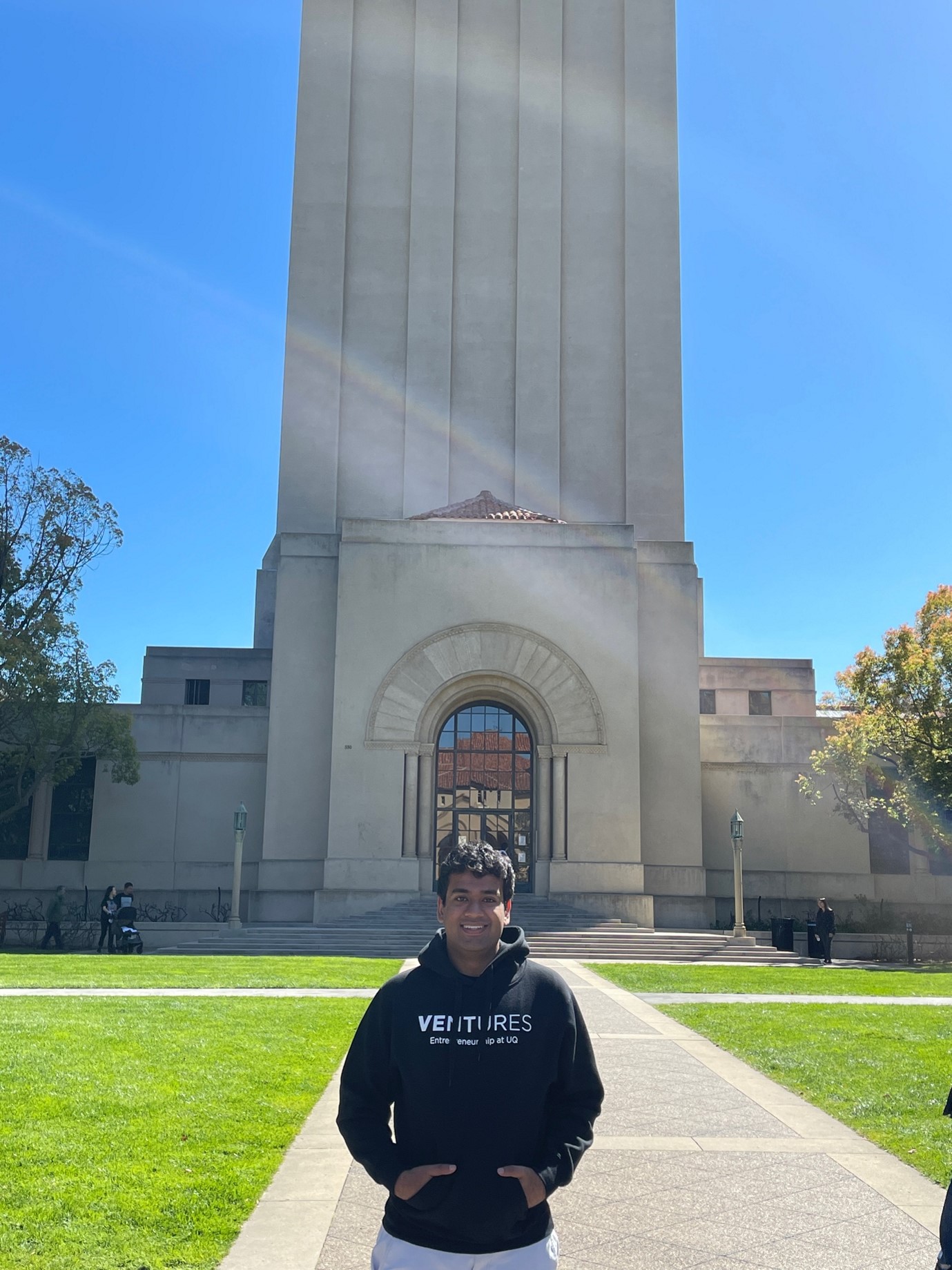 man standing in Stanford University courtyard in front of large building
