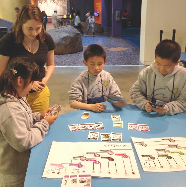 Dr Marcy playtesting an early version with two boys and one girl at the museum