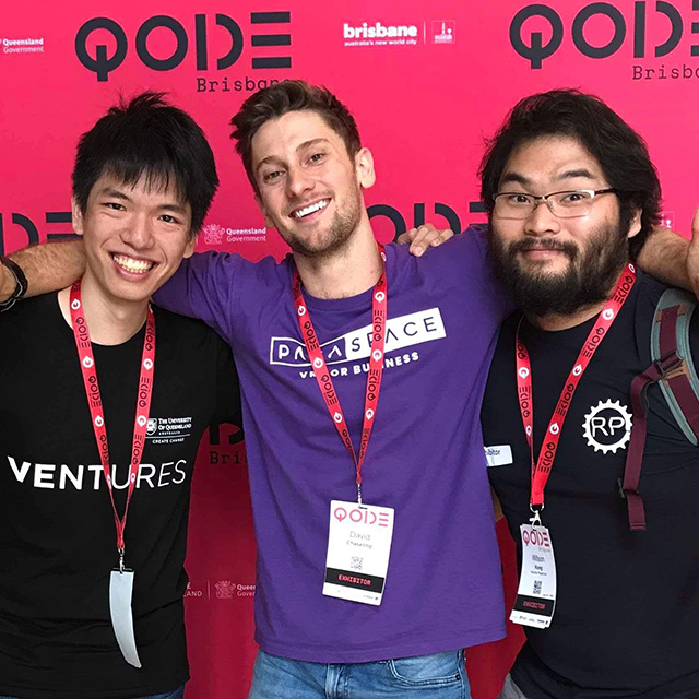 Ocean with two other young men at QODE exhibition behind its media wall