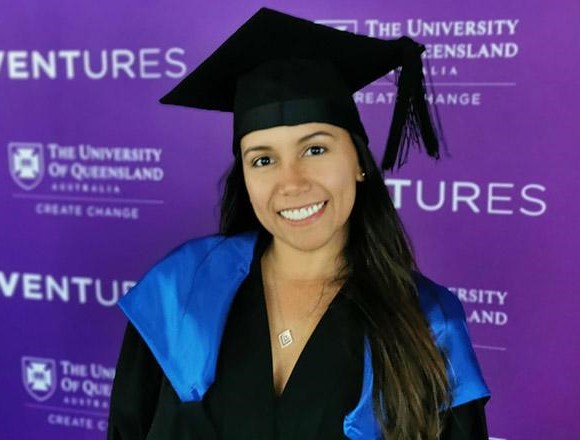 Dayana Jimenez in graduation gown in front of Ventures logos