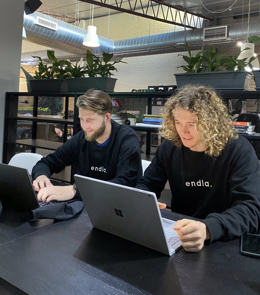 Riley O’Donnell and Michael Moore on laptops preparing for Y Combinator’s demo day to pitch to potential investors.