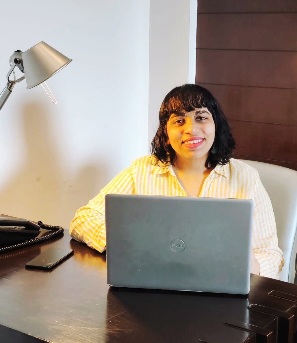 Harshita Rupani sitting at a desk with her laptop