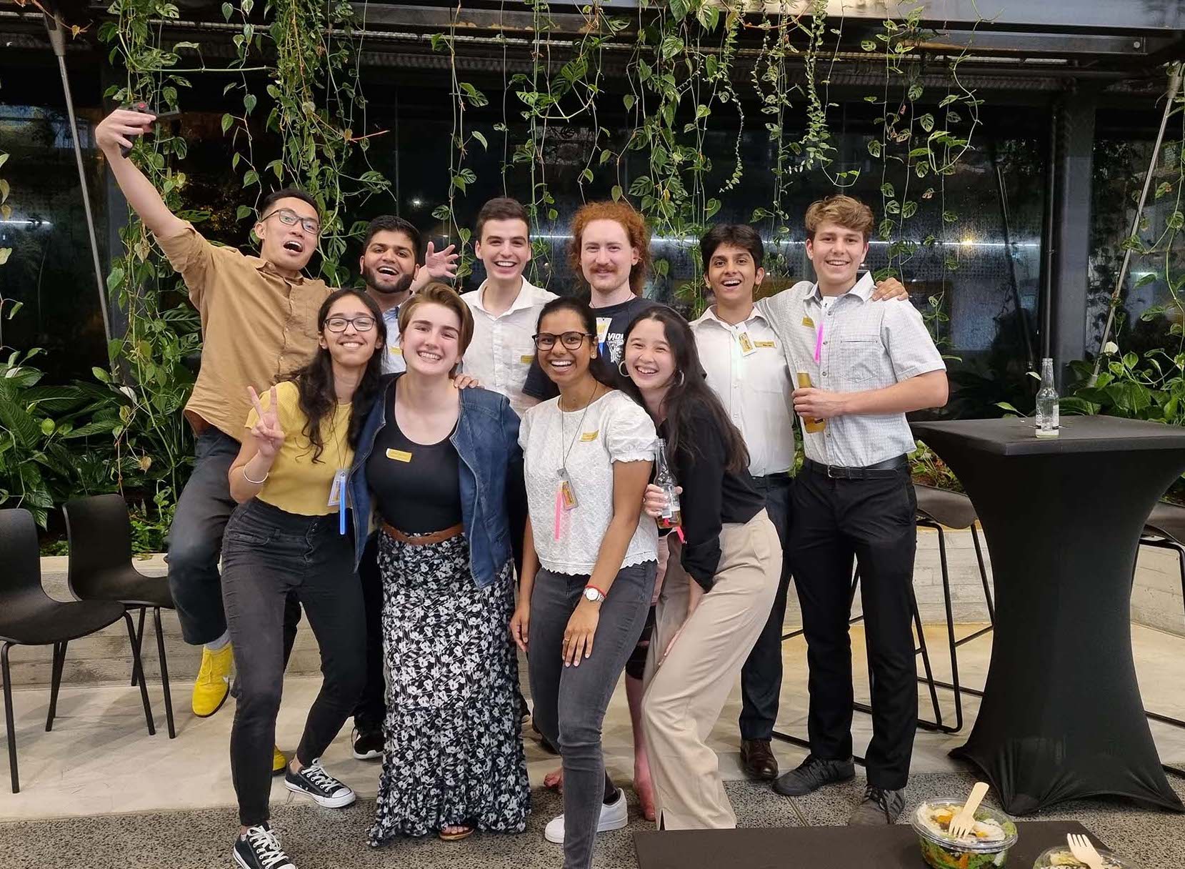 Group of student at event in front of green wall