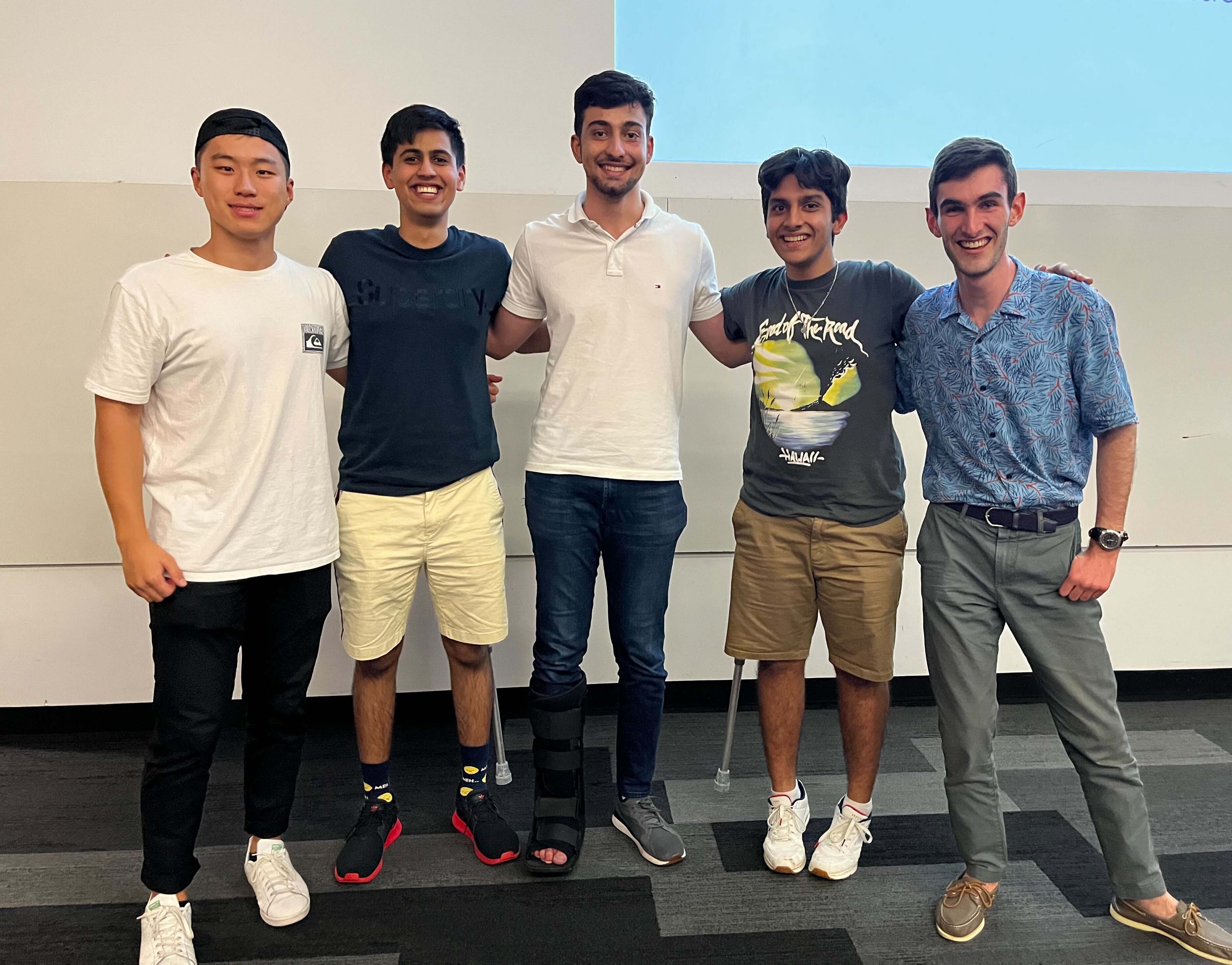 Team of five students standing at front of lecture theatre