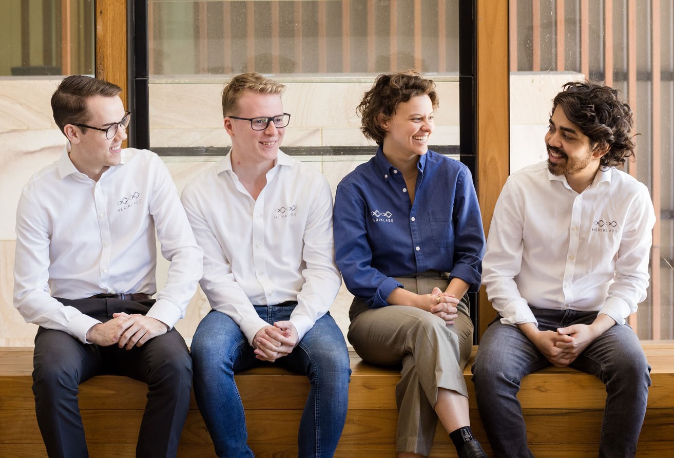 Herik labs team sitting together in a line and talking