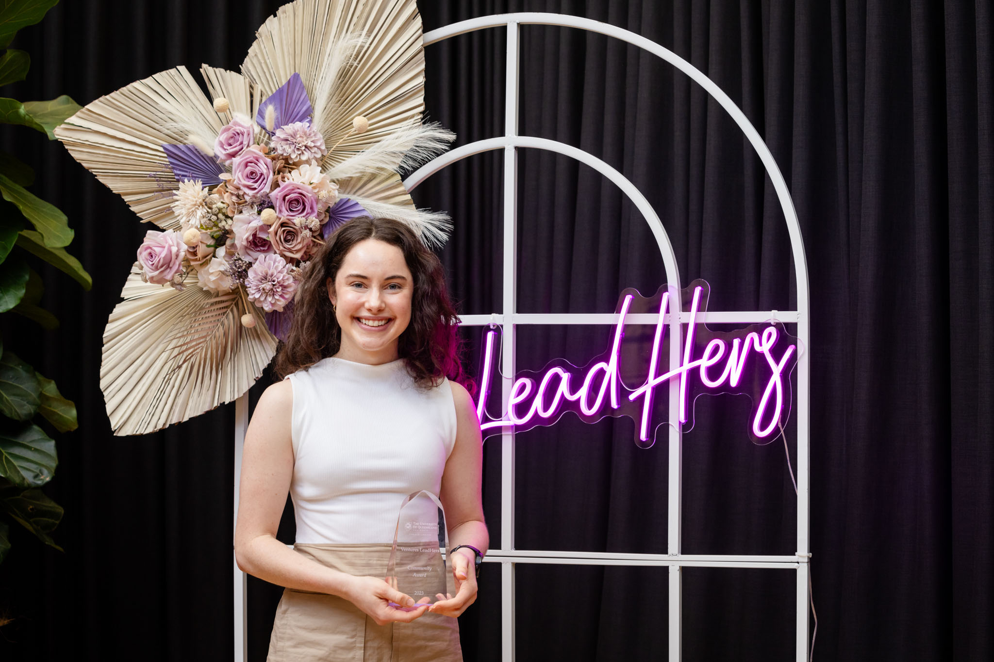 Clare Mahon standing in front of a LeadHers neon sign