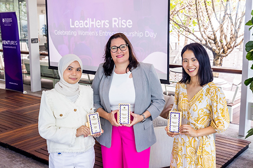 Photo of 3 women standing together holding their LeadHers Awards trophies