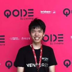 Ocean wearing a black t-shirt with VENTURES written on the front. He's standing in front of the QODE Brisbane pink wall advertising the QODE event