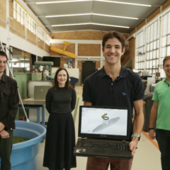 students in a makerspace holding up an image of a ventilator design