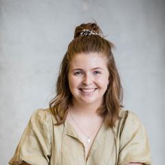 Ashley sitting for formal portrait with concrete background