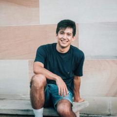Daniel Dunn sitting in front of sandstone