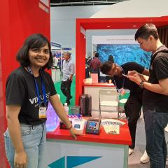 Swati standing at a stall, smiling