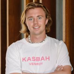 Finn Larson headshot standing in front of wood panelling