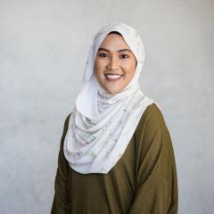 Naajihah Mahmood headshot with concrete wall background