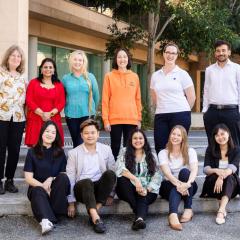 group of founders standing and sitting in two rows outside steps