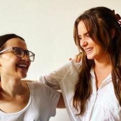 Ashley Baxter and Phoebe Long smiling and laughing at one another. 