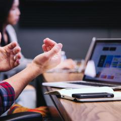 Person with laptop talking in a meeting