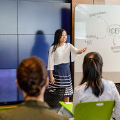 Person pitching to a group of students