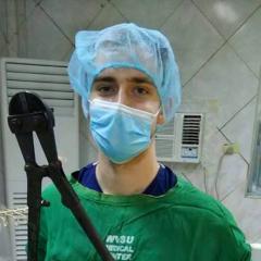 student hamming it up in a surgical room - with bolt cutters.
