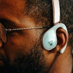 Black man wearing Augmented Designs' product concept, which looks like a bluetooth over the ear headset. 