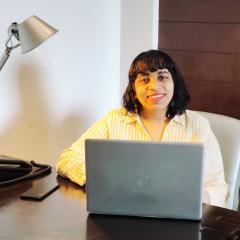 Harshita Rupani sitting at a desk with a laptop