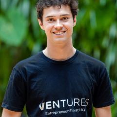 Tom Bizzell Chief Student Entrepreneur in Ventures tshirt in front of green wall