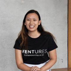 Jenny Nguyen in Ventures tshirt sitting in front of concrete wall - modern look