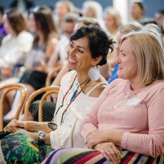 Two women in audience listening to panel event